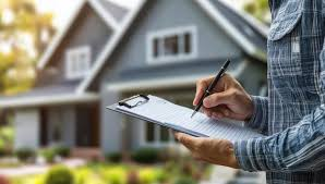 Home inspector taking notes on a clipboard in front of a house